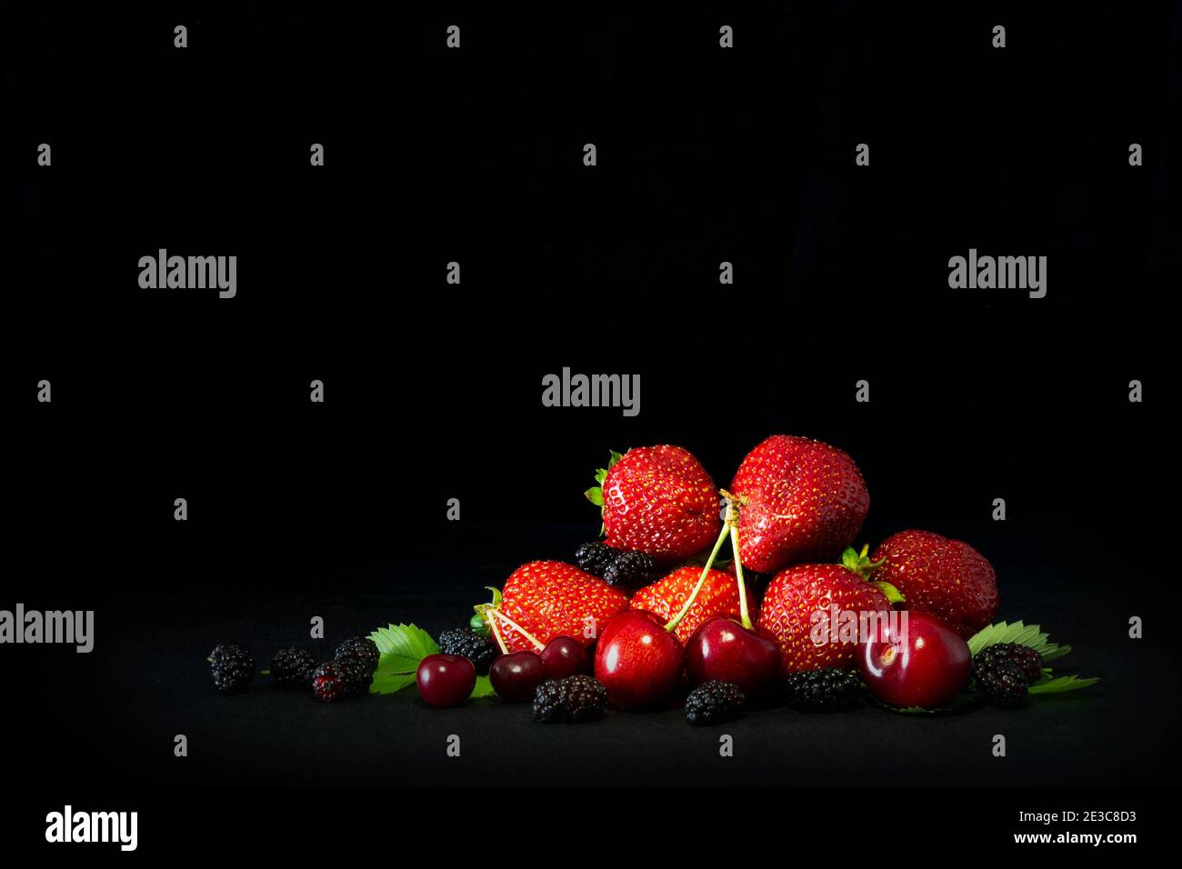 Berries closeup assorted fresh mix colorful arrangement in studio on dark background Stock Photo