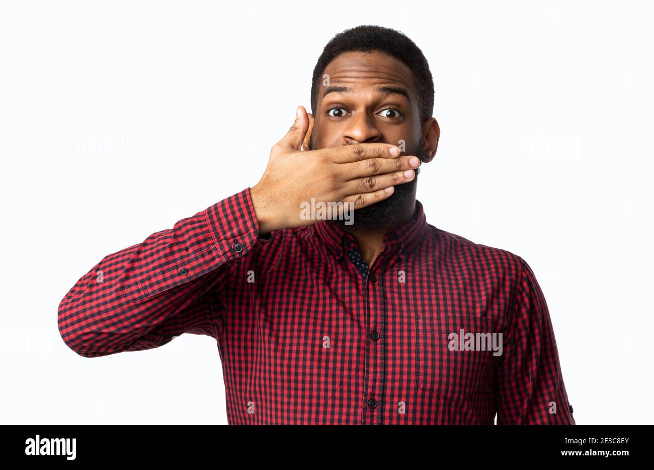 African Man Covering Mouth With Hand Posing Over White Background Stock Photo
