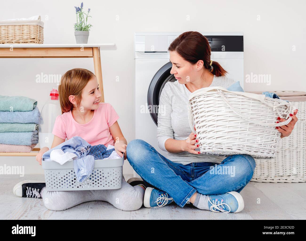 Little girl helping mother during washing Stock Photo