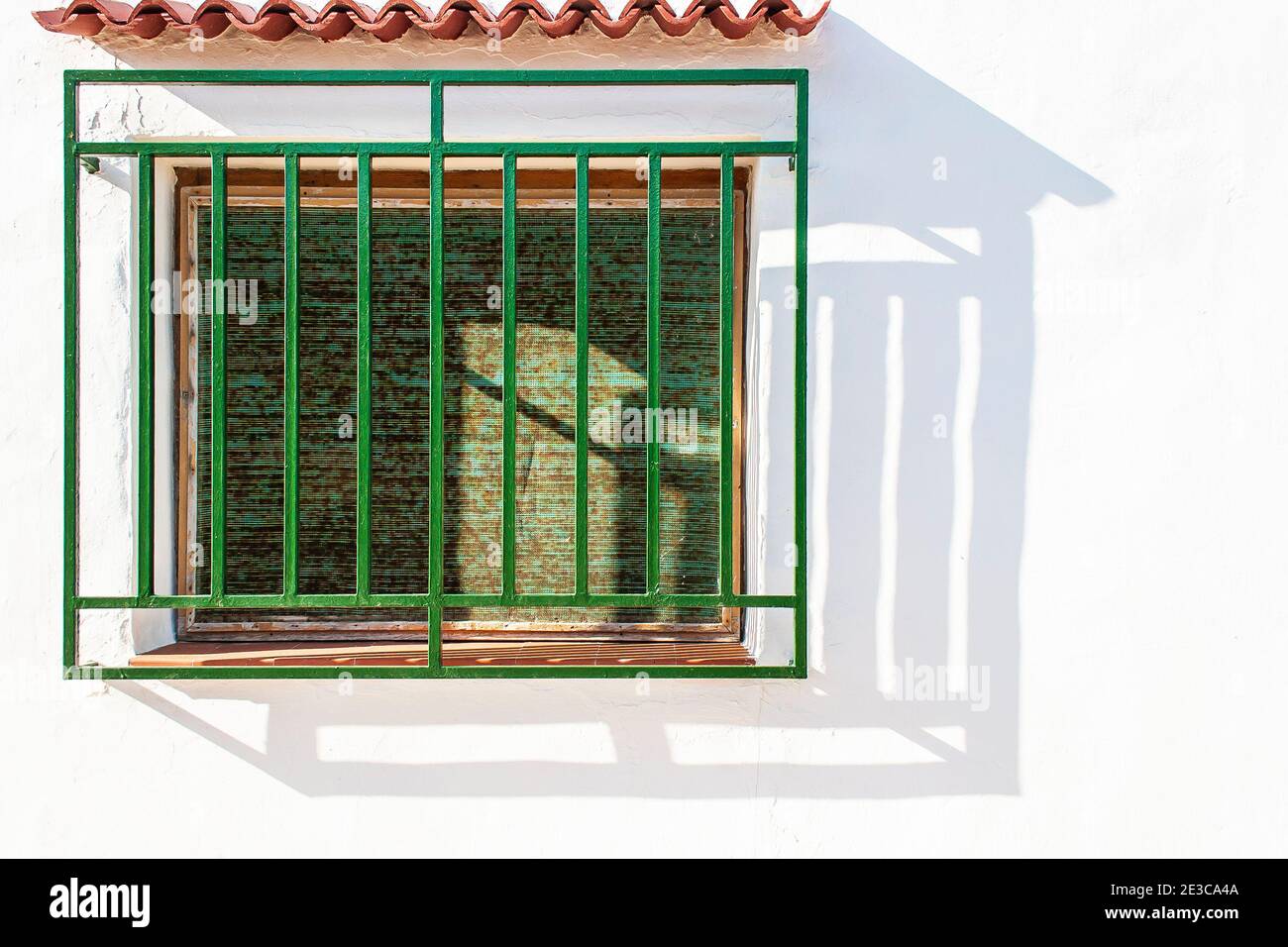 Traditional Spanish villa window with green blinds and grill in the coastal town of Oliva in the Valencian region of Spain Stock Photo