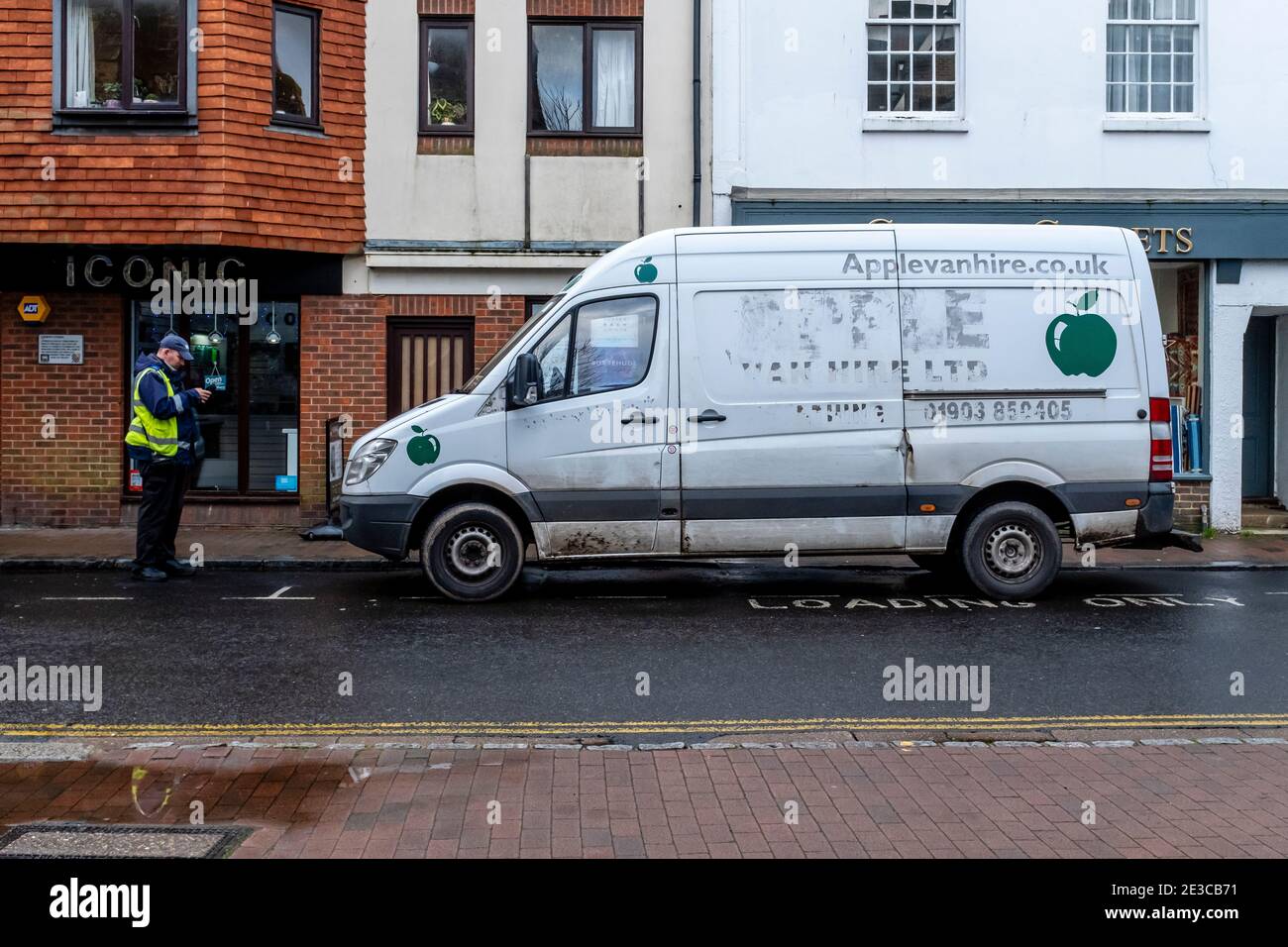 A Traffic Warden Gives A Parking Ticket To A Van On The High Street, Lewes, Sussex, UK. Stock Photo