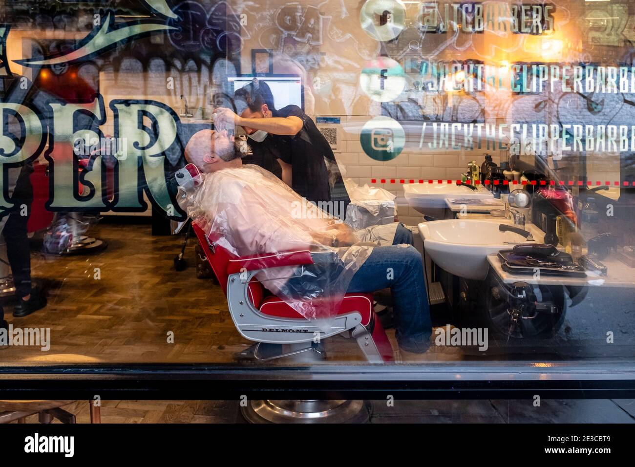 A Man Has A Beard and Moustache Trim At A Barber Shop In Brick Lane, London, UK. Stock Photo