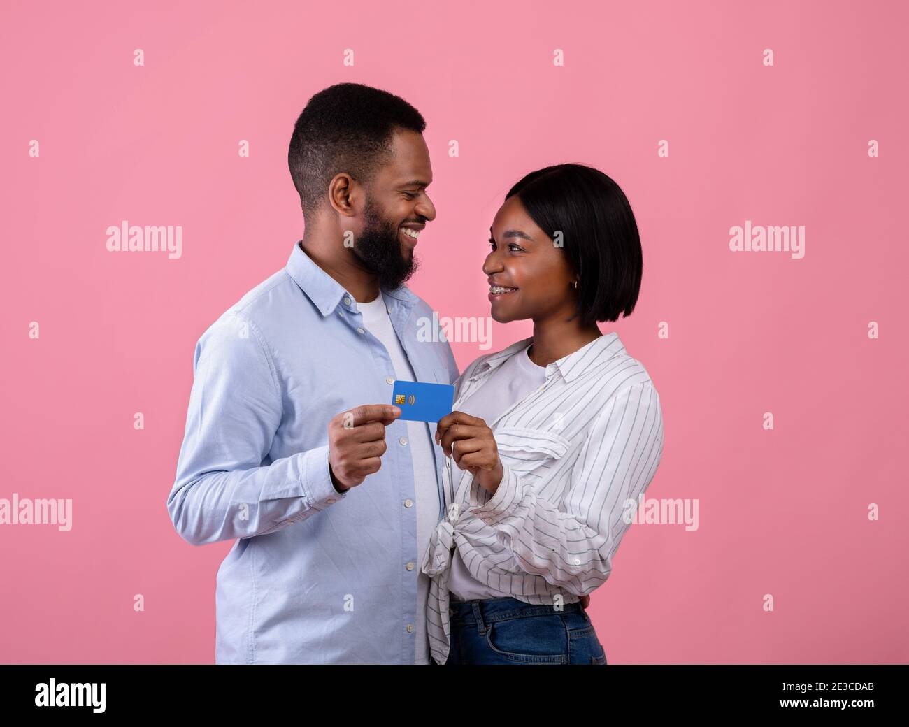 Happy millennial African American couple with credit card looking at ...