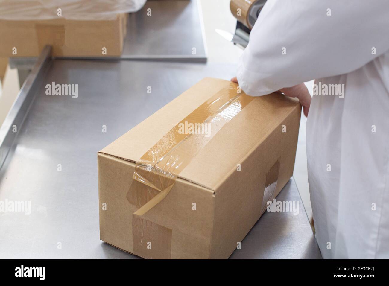 worker packs boxes with products in a factory, industry. Process, transportation Stock Photo