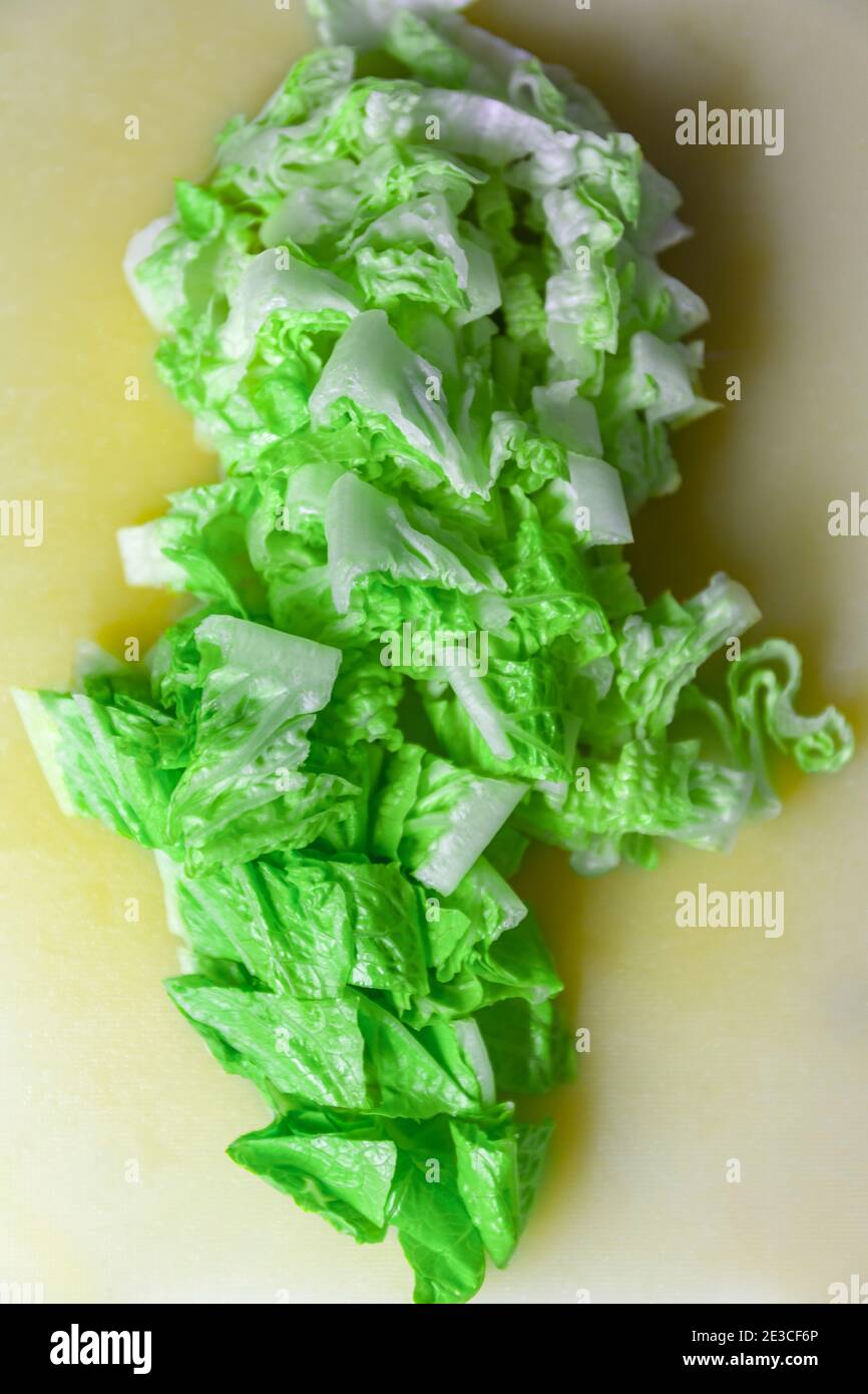 Close up view from above of fresh green chopped lettuce on chopping board Stock Photo