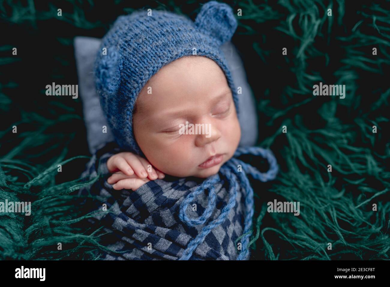 Cute sleeping newborn wearing blue knitted hat Stock Photo Alamy