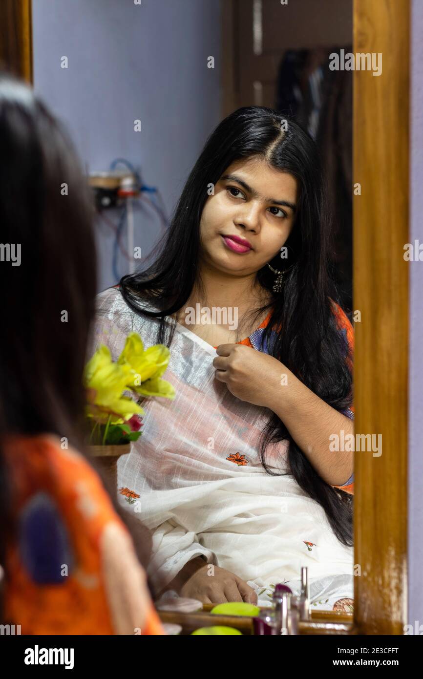 https://c8.alamy.com/comp/2E3CFFT/a-beautiful-indian-woman-in-white-saree-looking-herself-in-mirror-with-smiling-face-2E3CFFT.jpg