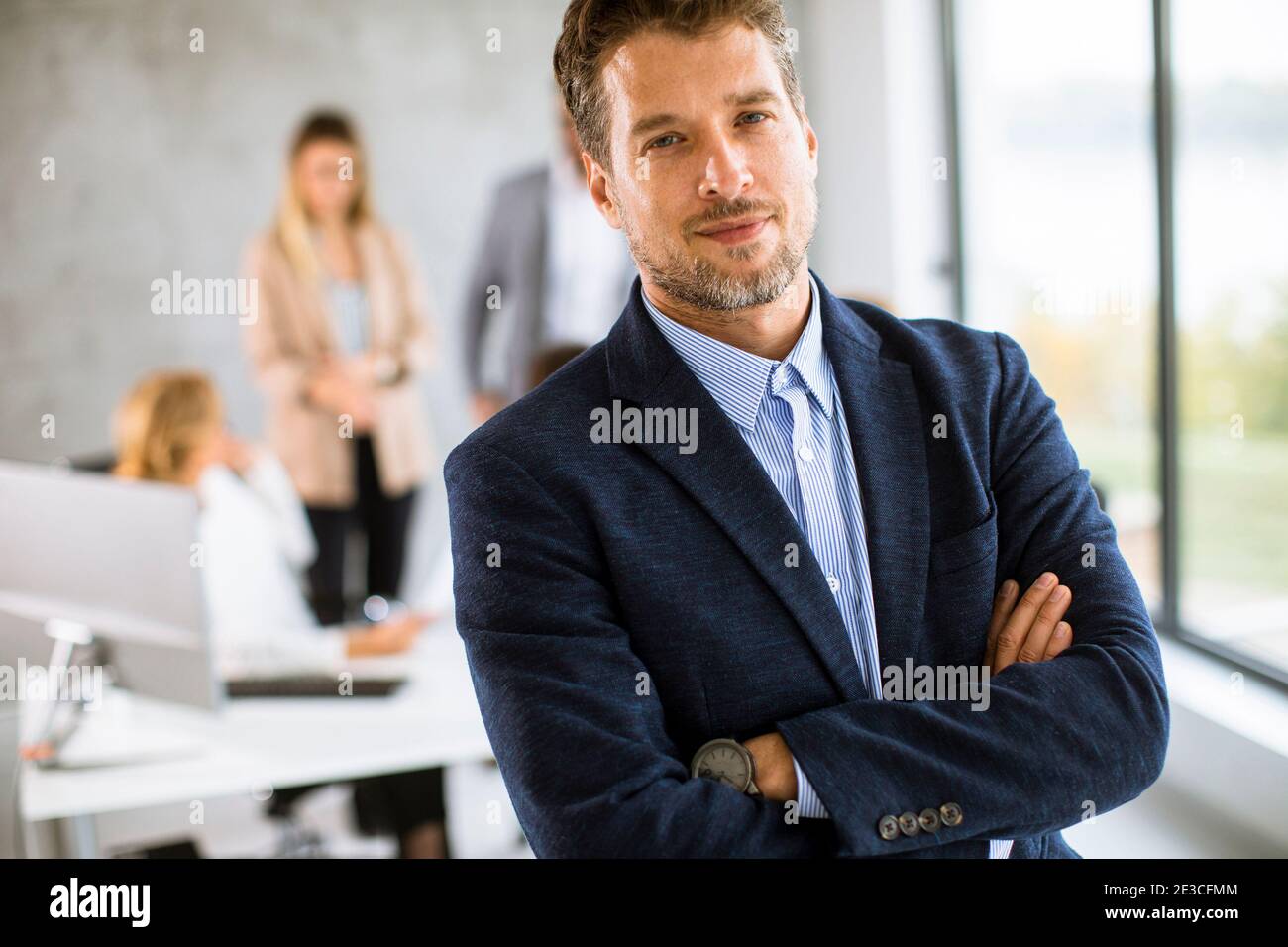 Handsome young business man standing confident in the office in front ...