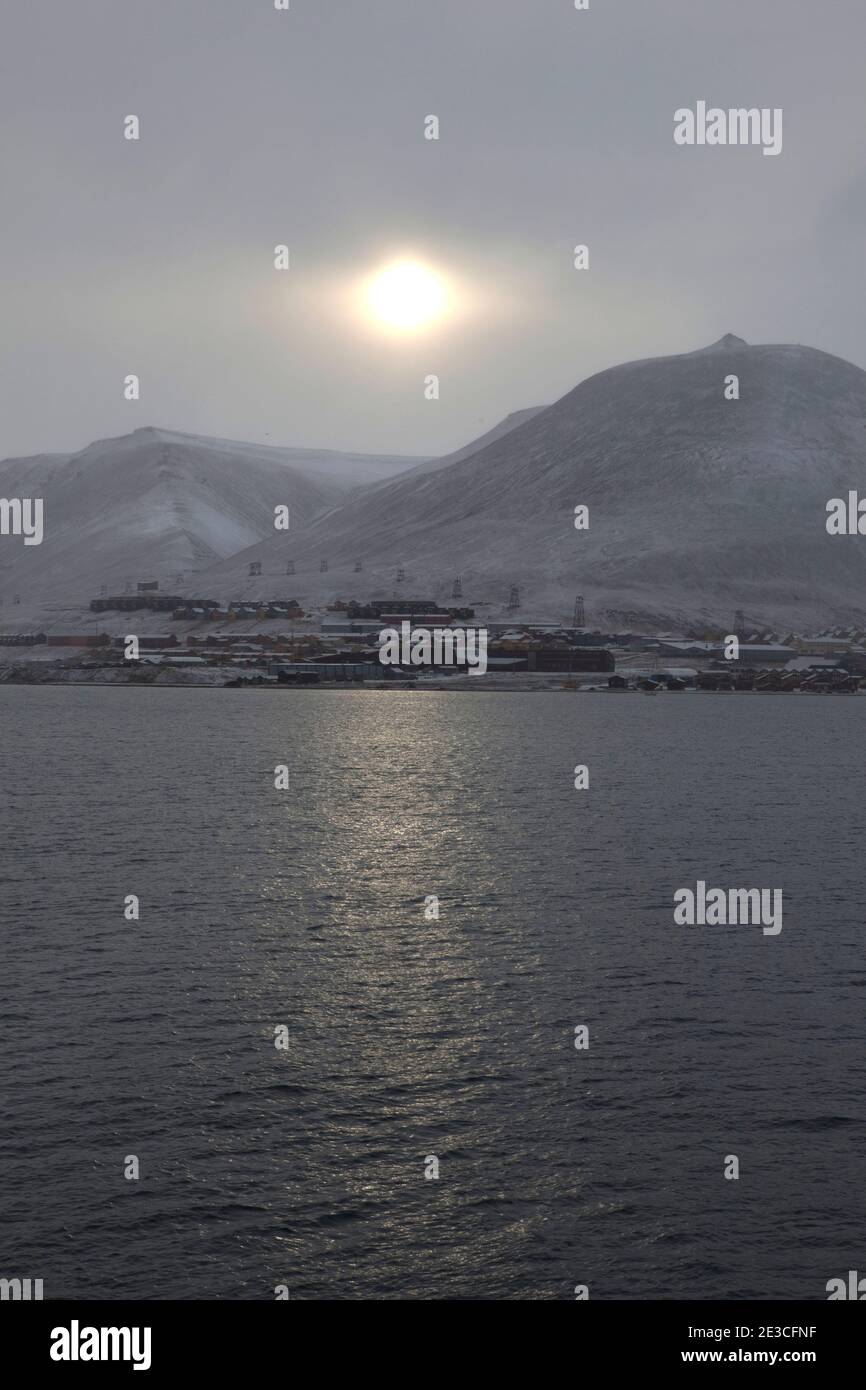 The sun pushes through a fog over the town of Longyearbyen, Svalbard. The northernmost settlement with more than 1,000 people on earth, and is quite w Stock Photo