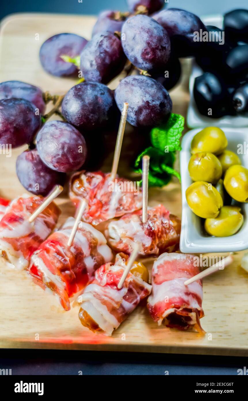 Delicious figs wrapped in bacon served with blue cheese, grapes and