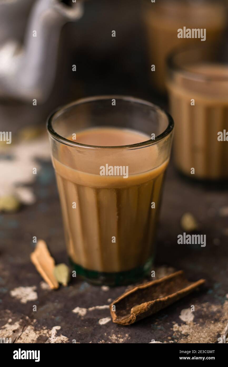 Indian chai in glass cups with metal kettle and other masalas to make
