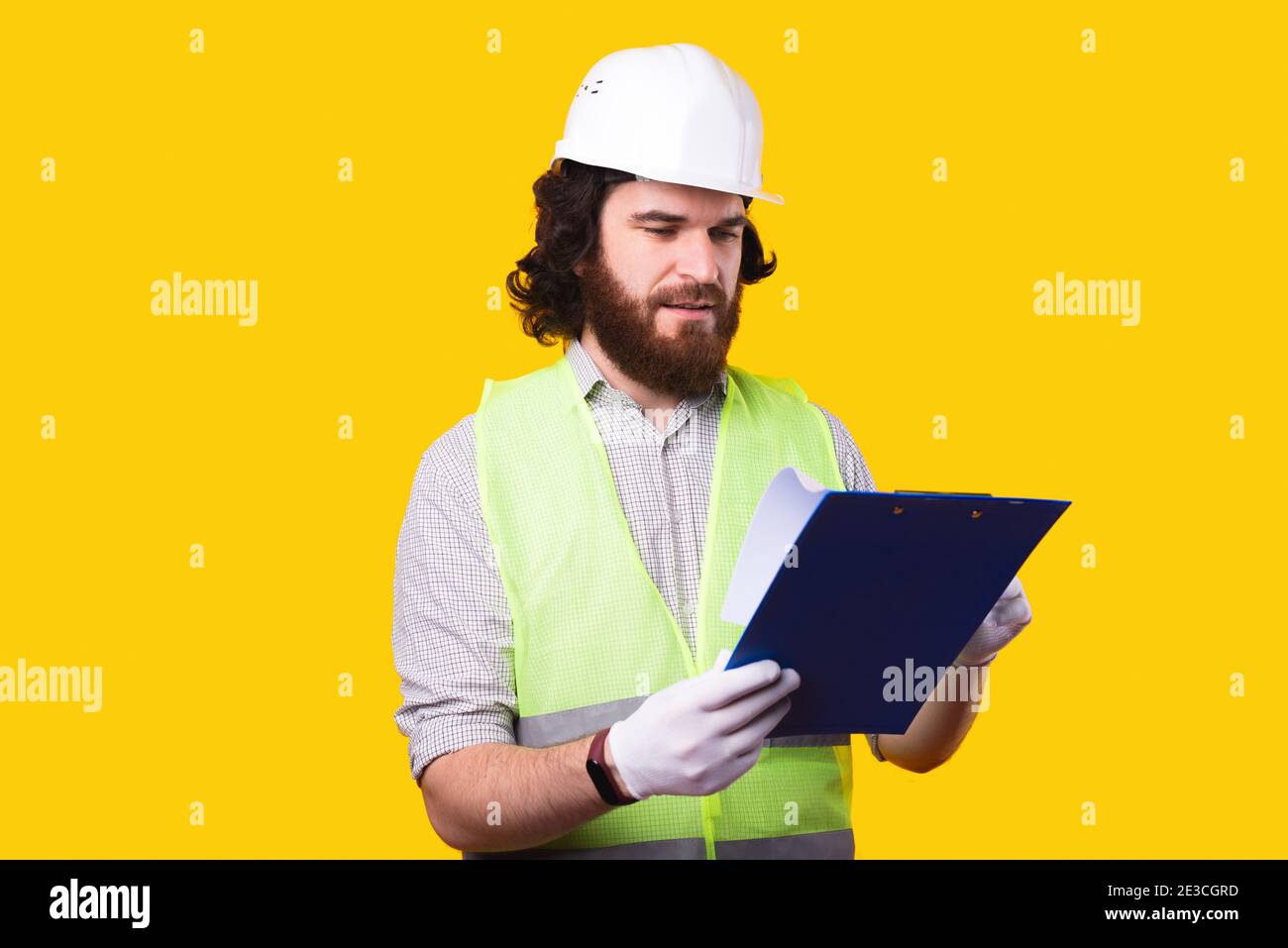 Photo of architect looking at papers and wearing white hard hat Stock Photo Alamy