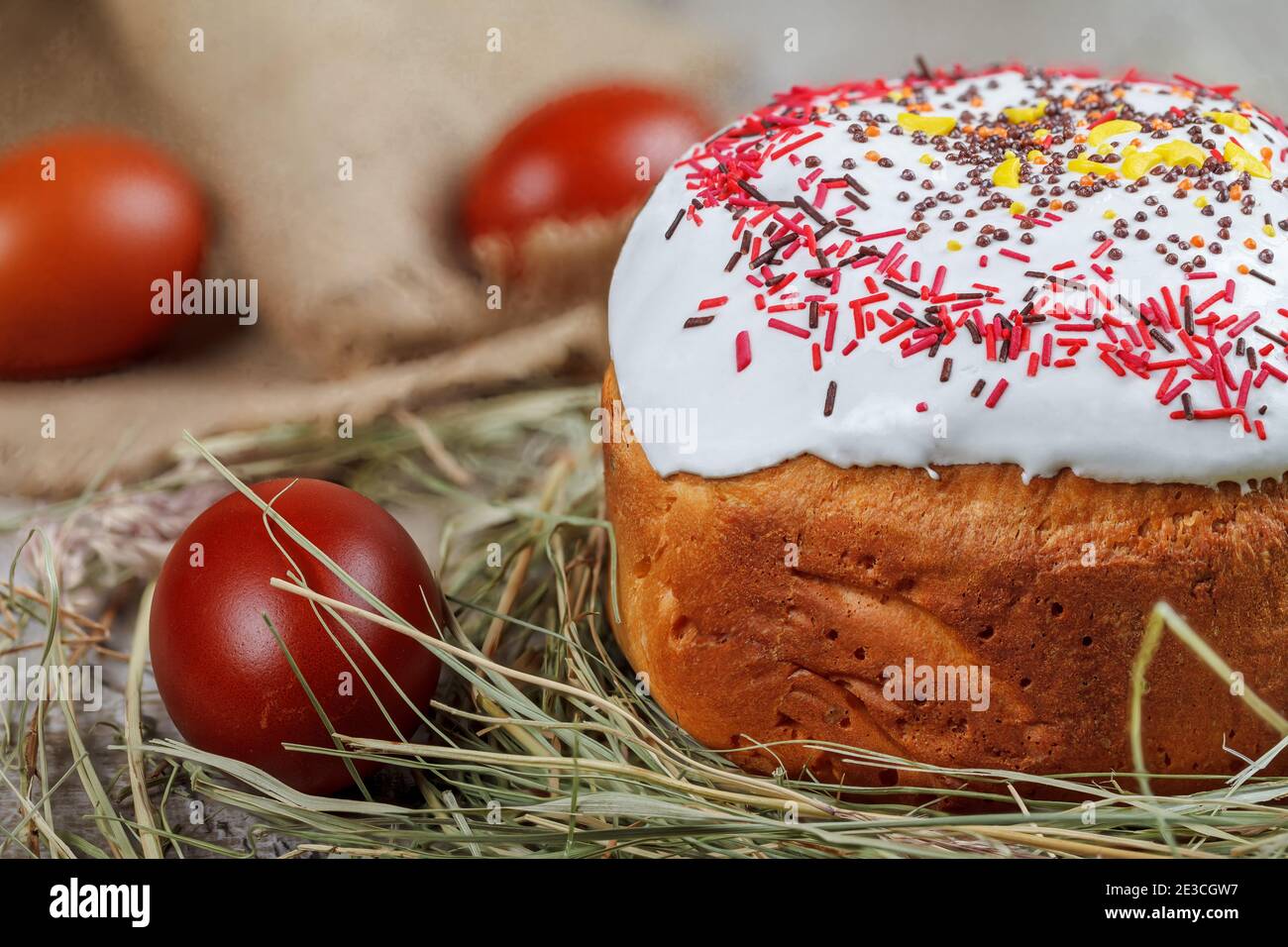 Festive Easter cake on a light background, decorated with multi-colored dragees. Painted Easter eggs as an attribute of Easter. Close-up. Studio light Stock Photo