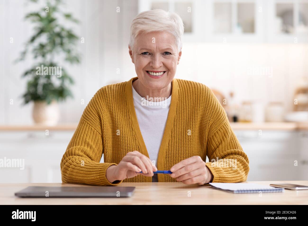 Happy senior woman getting ready before webinar Stock Photo