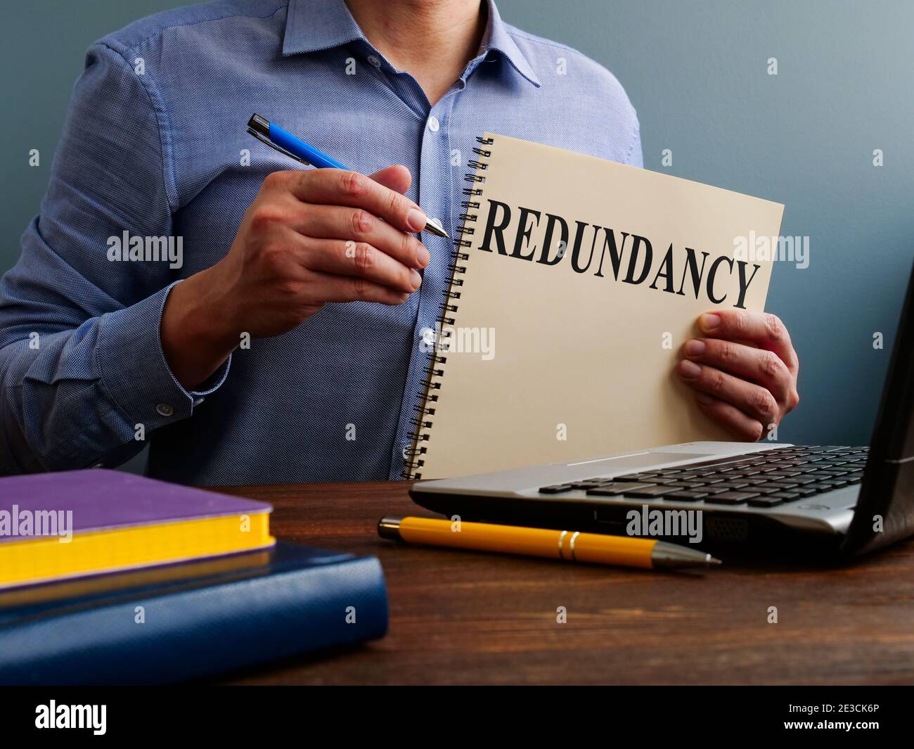 Redundancy concept. Man at the table holds papers. Stock Photo