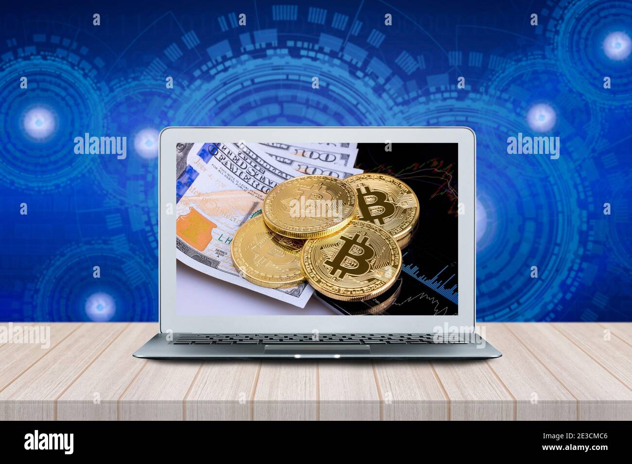 Smart Computer with Bitcoins on investment money moving graph on screen on wood table with futuristic technology background. Stock Photo