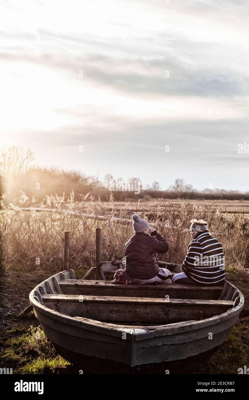 Coffee break UK; Two people sitting outside having a break and a coffee, while walking in the fens, example of English lifestyle, Cambridgeshire UK Stock Photo