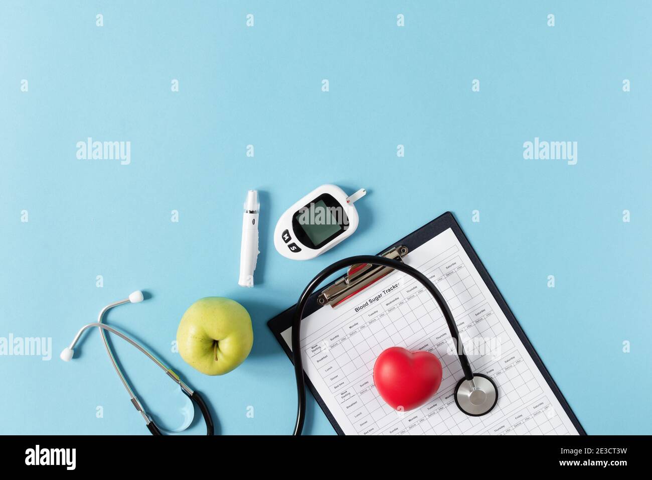 Fresh apple fruit with and diabetic test top view on blue