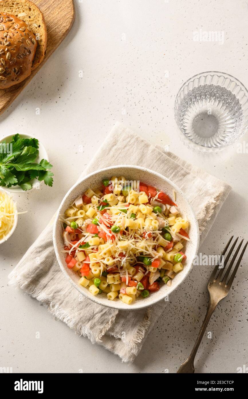 Italian salad with ditalini pasta, tomatoes, vegan sausage on white table. View from above. Stock Photo