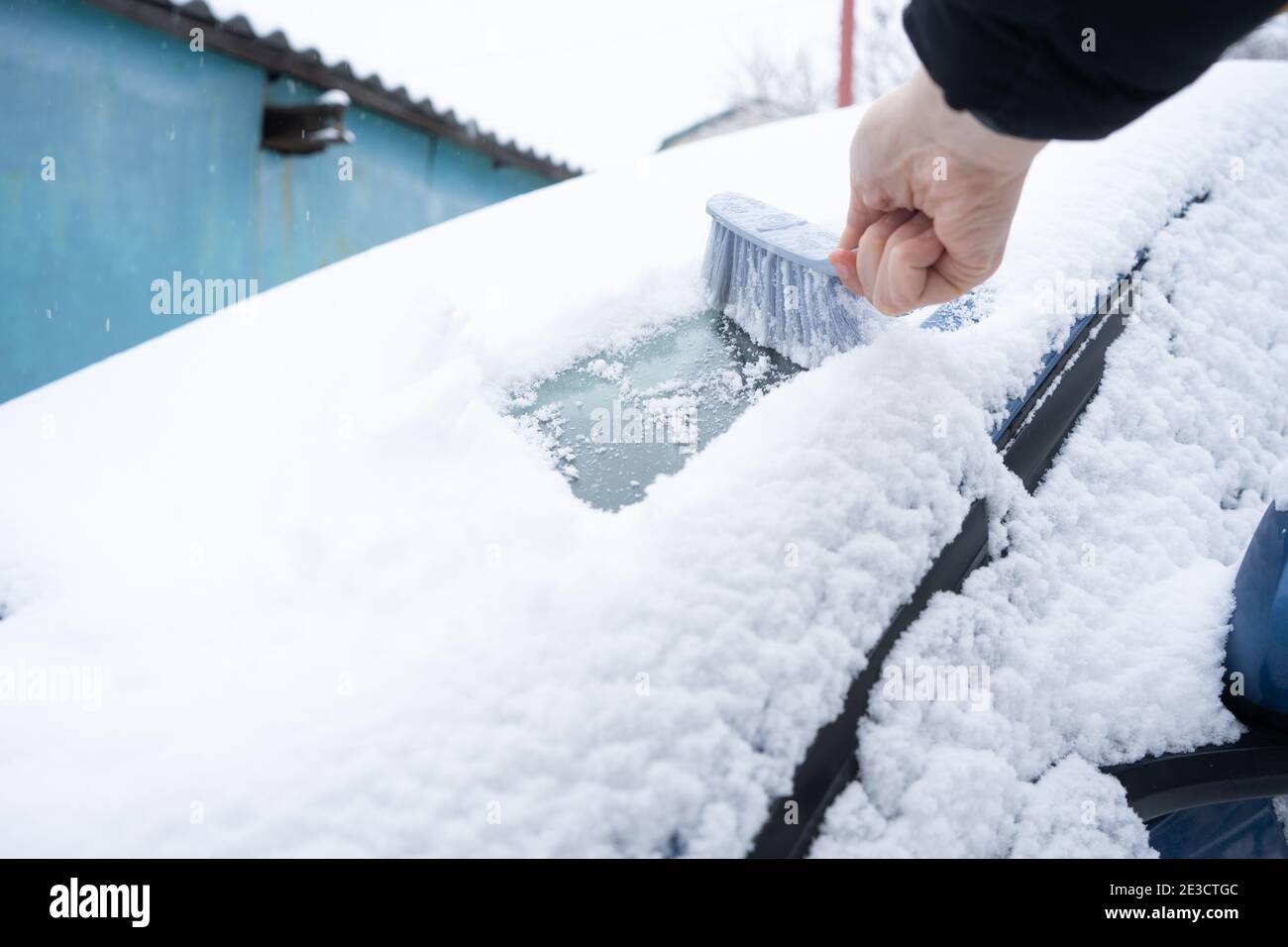 Clearing snow from the car windshield with car brush Stock Photo Alamy