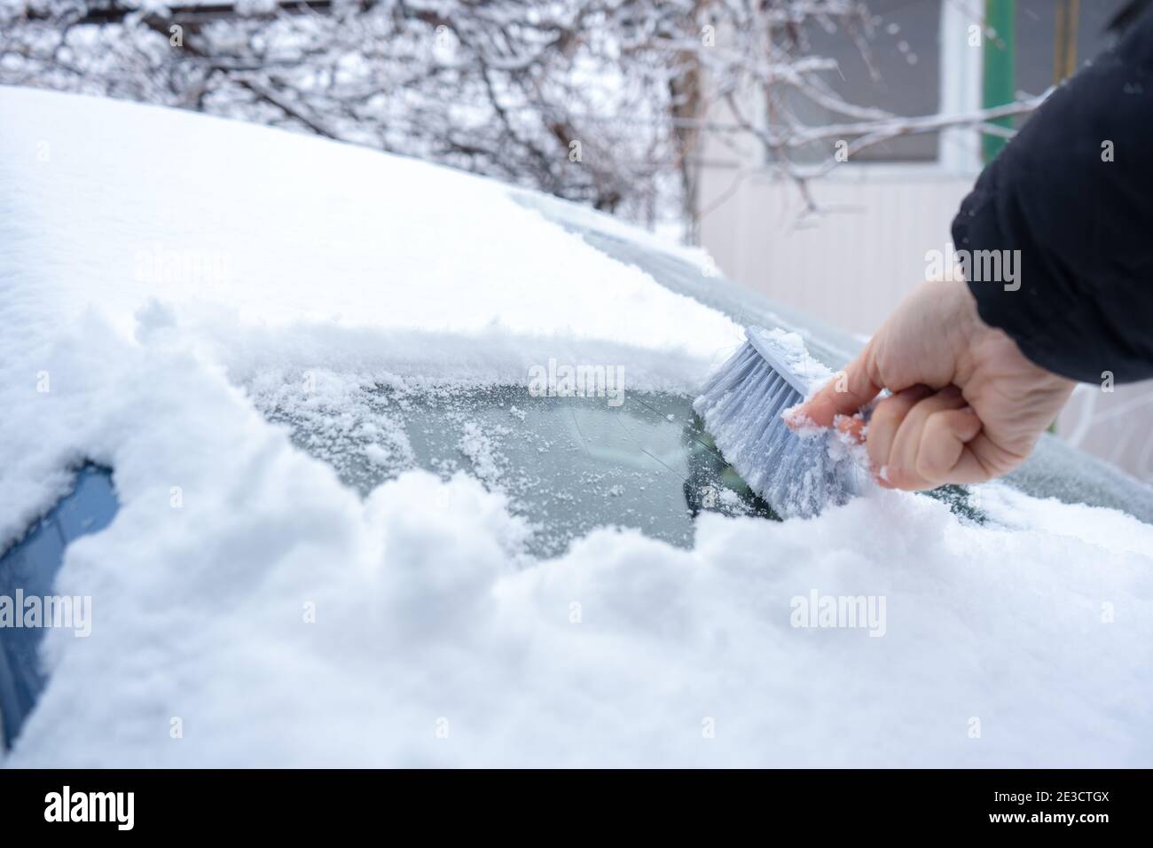 Clearing snow from the car windshield with car brush Stock Photo Alamy