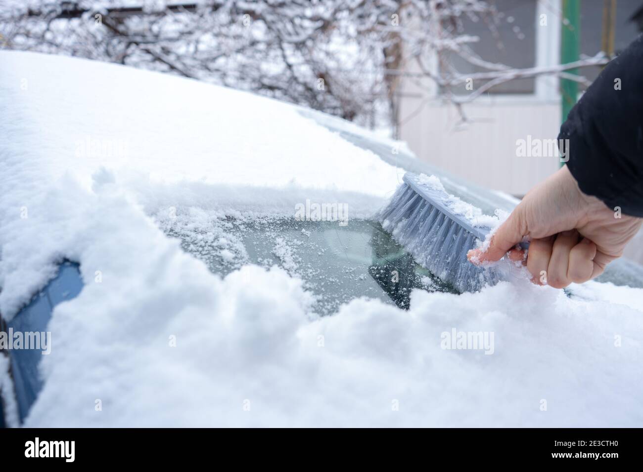 Clearing snow from the car windshield with car brush Stock Photo Alamy