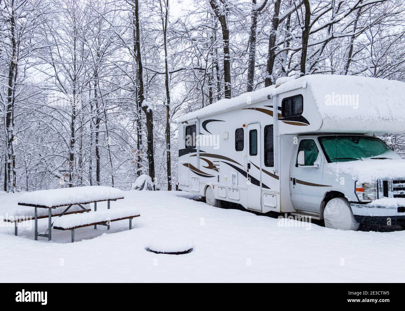 An RV on a campsite while snow storm, winterize, storage for winter season Stock Photo
