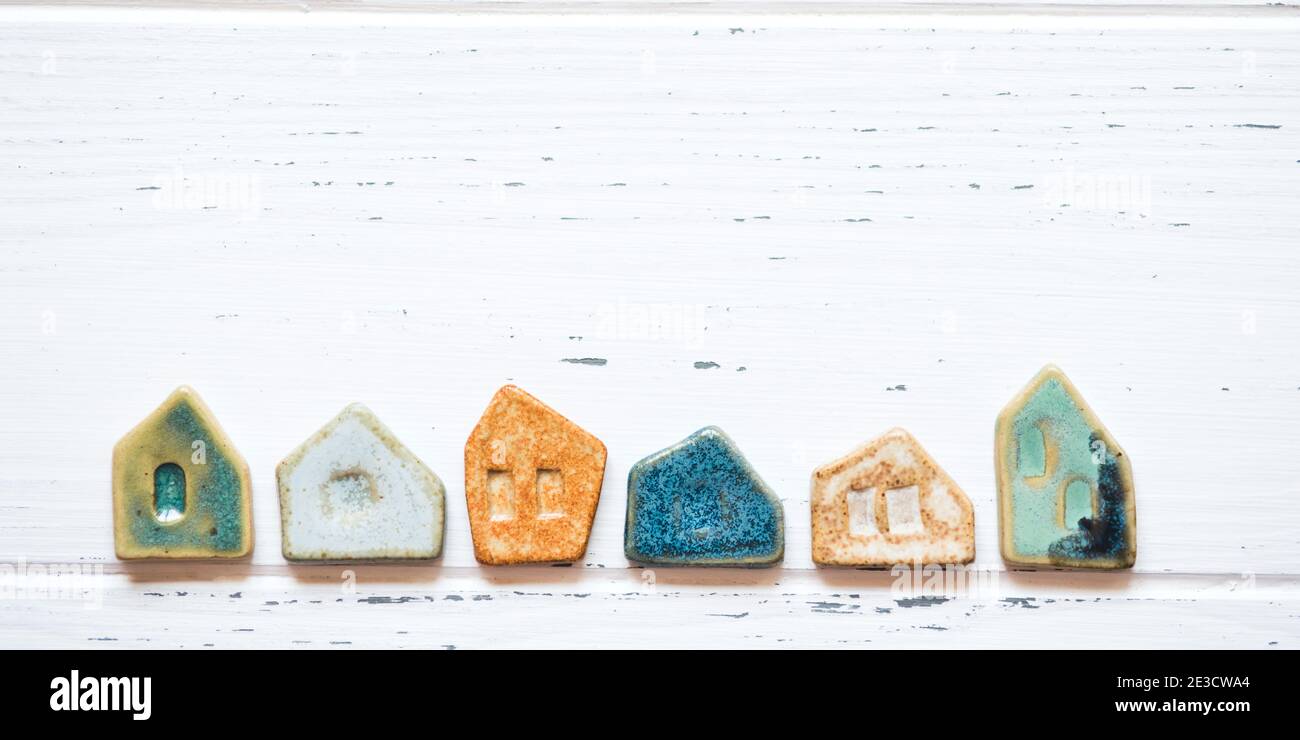 Colorful ceramic houses on a white wooden background. Stock Photo