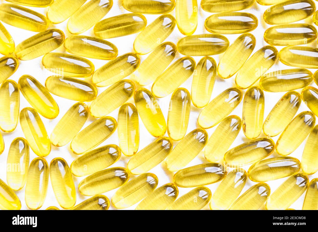 Fish oil fat capsules with omega 3 and vitamin D on white background