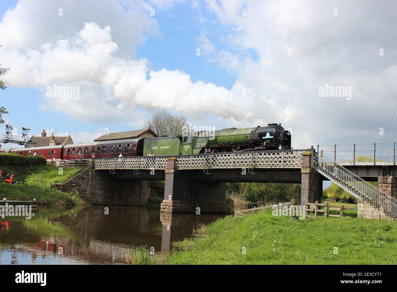 Peppercorn A1 class 60163 Tornado departs from Wansford station at the Nene Valley Railway and chuffs over the river bridge. Stock Photo