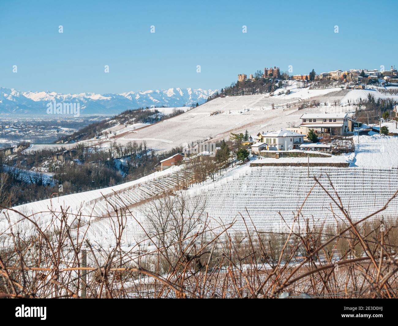 Italy Piedmont: Barolo wine yards unique landscape winter, Novello medieval village castle on hill top, the Alps snow capped mountains background, ita Stock Photo