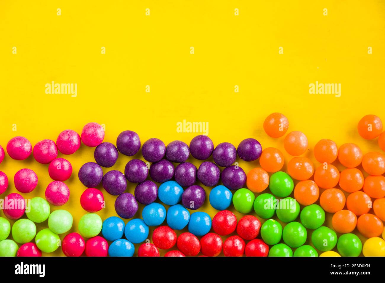 Skittles candy on the yellow table, colorful sweet candy background, high  angle view Stock Photo - Alamy