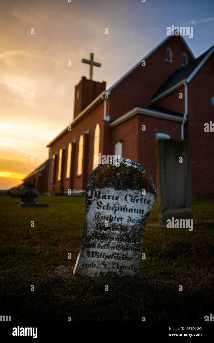 An old headstone in the German cemetery at Sauers Lutheran Church in Jackson County, IN.  Taken during the sunset. Stock Photo