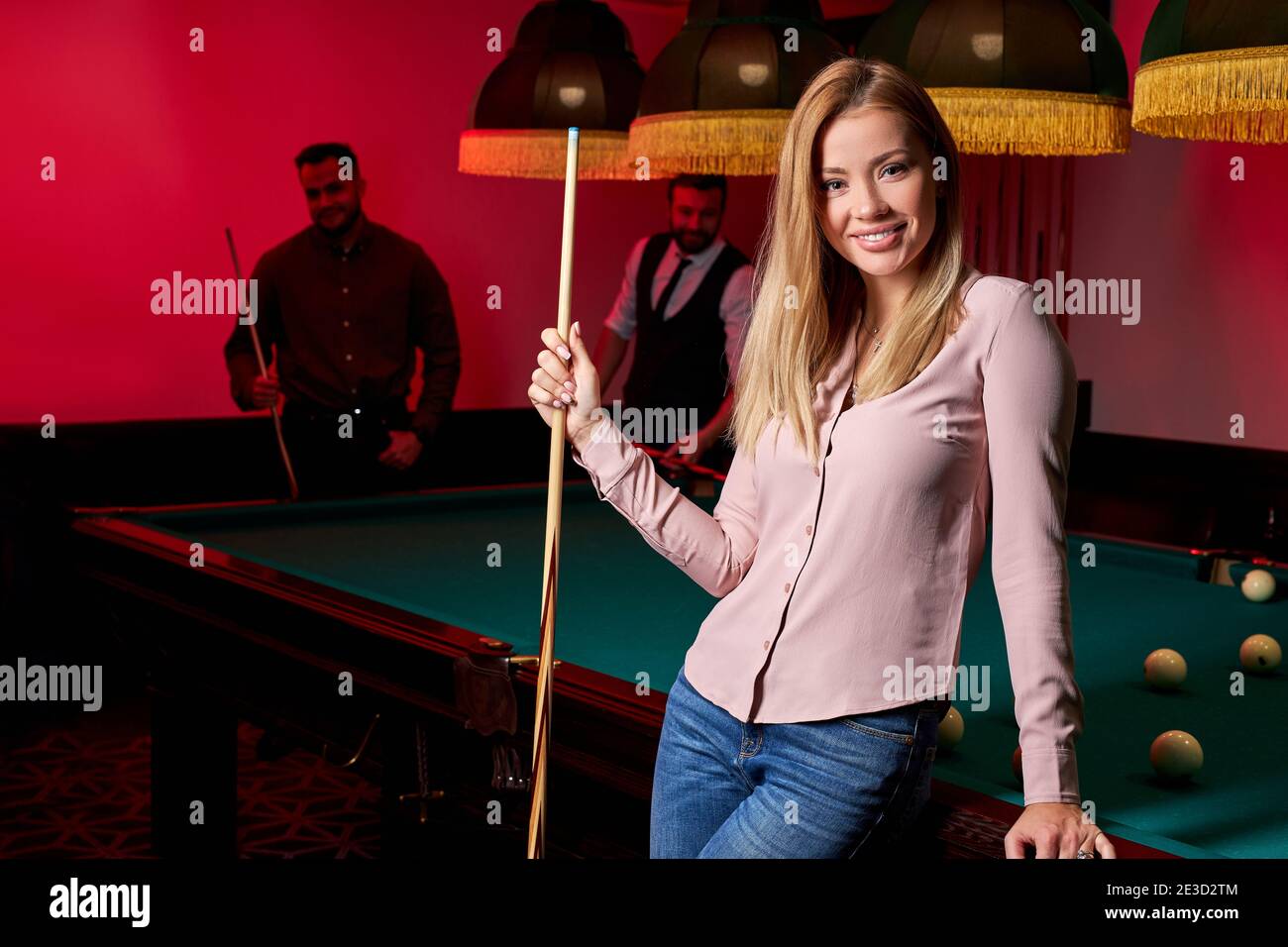 pretty woman in the bar next to billiards table pool, people playing ...