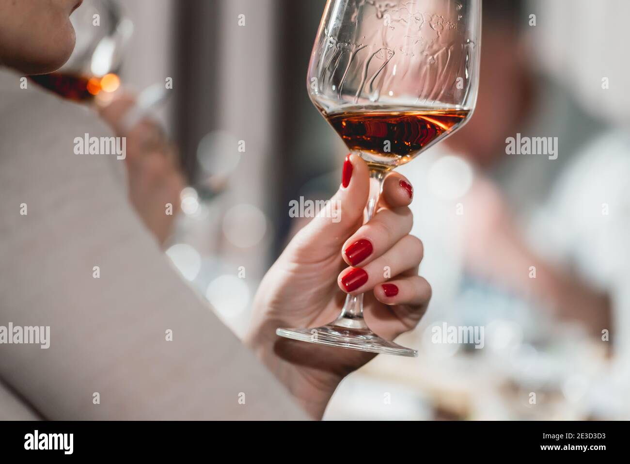 woman holds glass of red wine. people consider the color of the wine ...