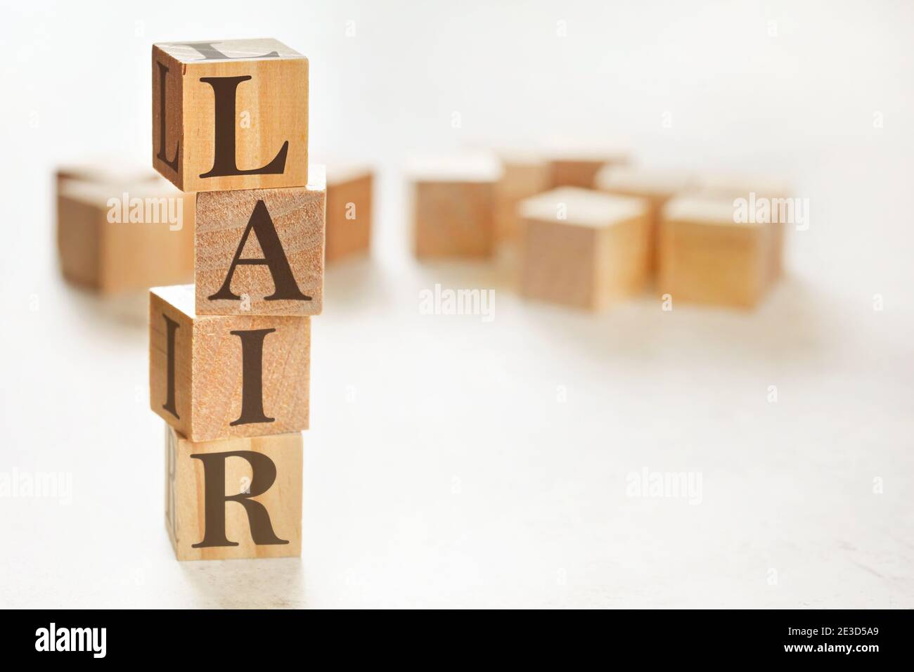 Four wooden cubes arranged in stack with text LAIR (meaning Listen