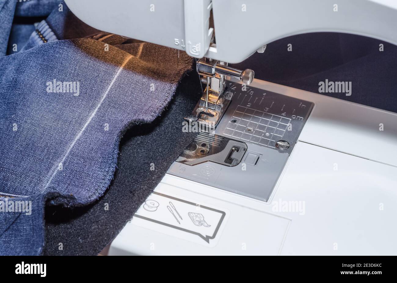 Sewing machine foot on denim fabric overcasting process Stock Photo Alamy