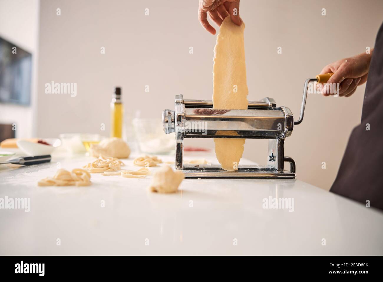 Careful cook using pasta machine in the kitchen Stock Photo - Alamy