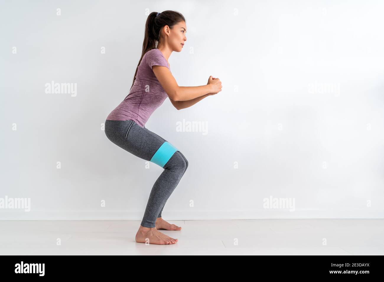 Resistance band fitness woman doing squat exercise with fabric booty band stretching strap. Crab walk squatting workout girl training at home Stock Photo Alamy