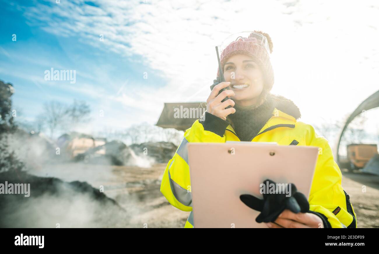 Manager in biomass and landfill operation using her radio in front of machines Stock Photo