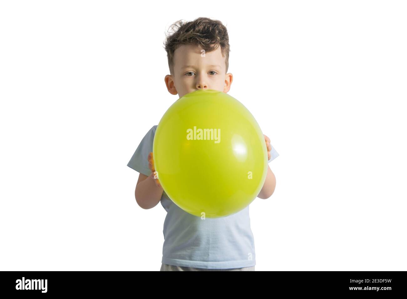 Funny boy blowing up a yellow balloon isolated on white background ...