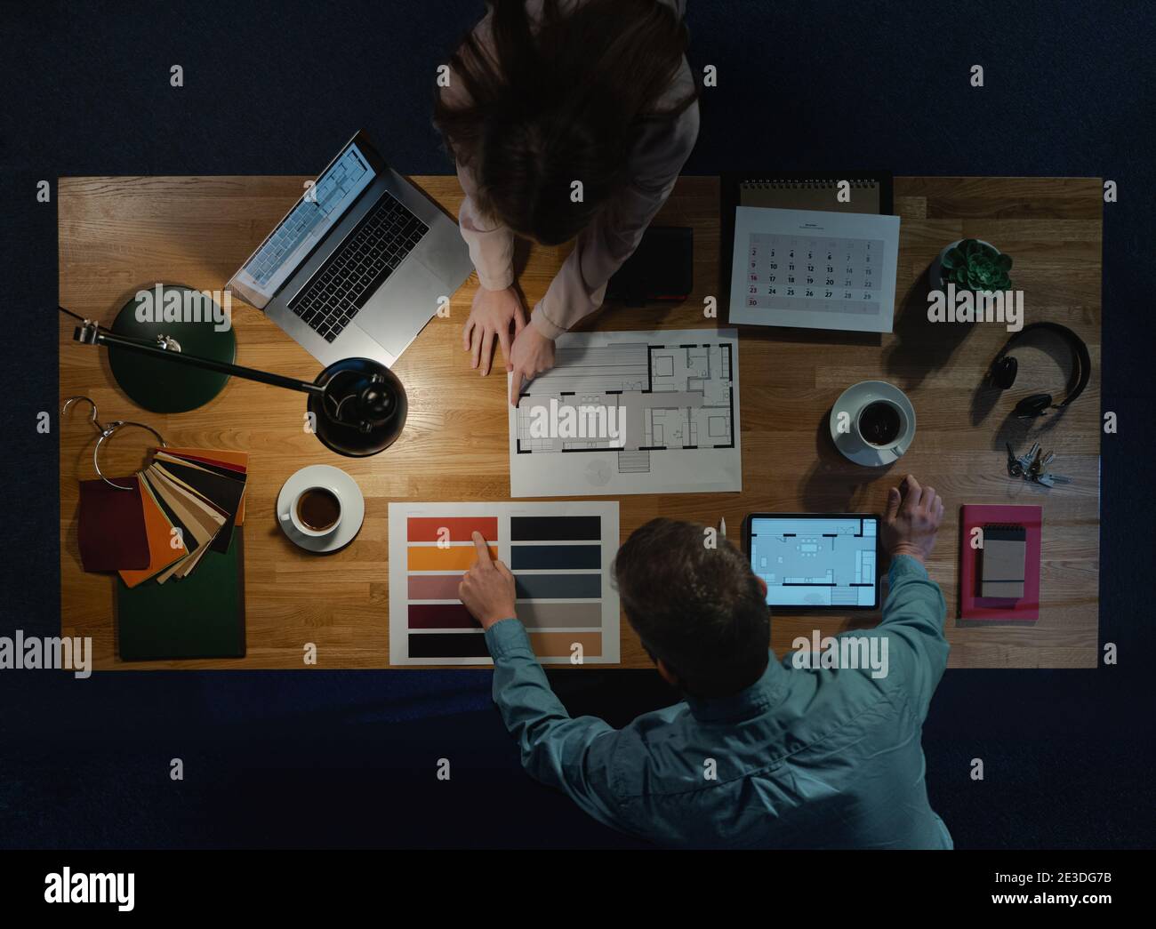 Top view of architects working on computer at desk with paperwork in office. Stock Photo