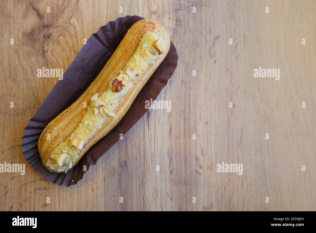 Top view traditional french chocolate eclair on wooden table, copy space Stock Photo