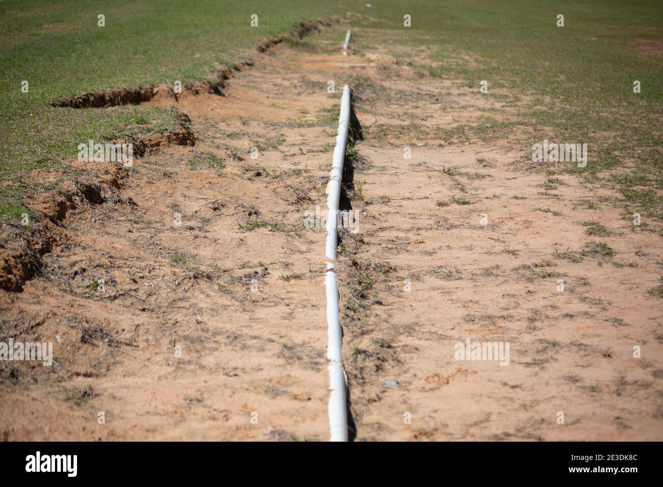 Long PVC pipe leading through a ditch into the distance Stock Photo Alamy