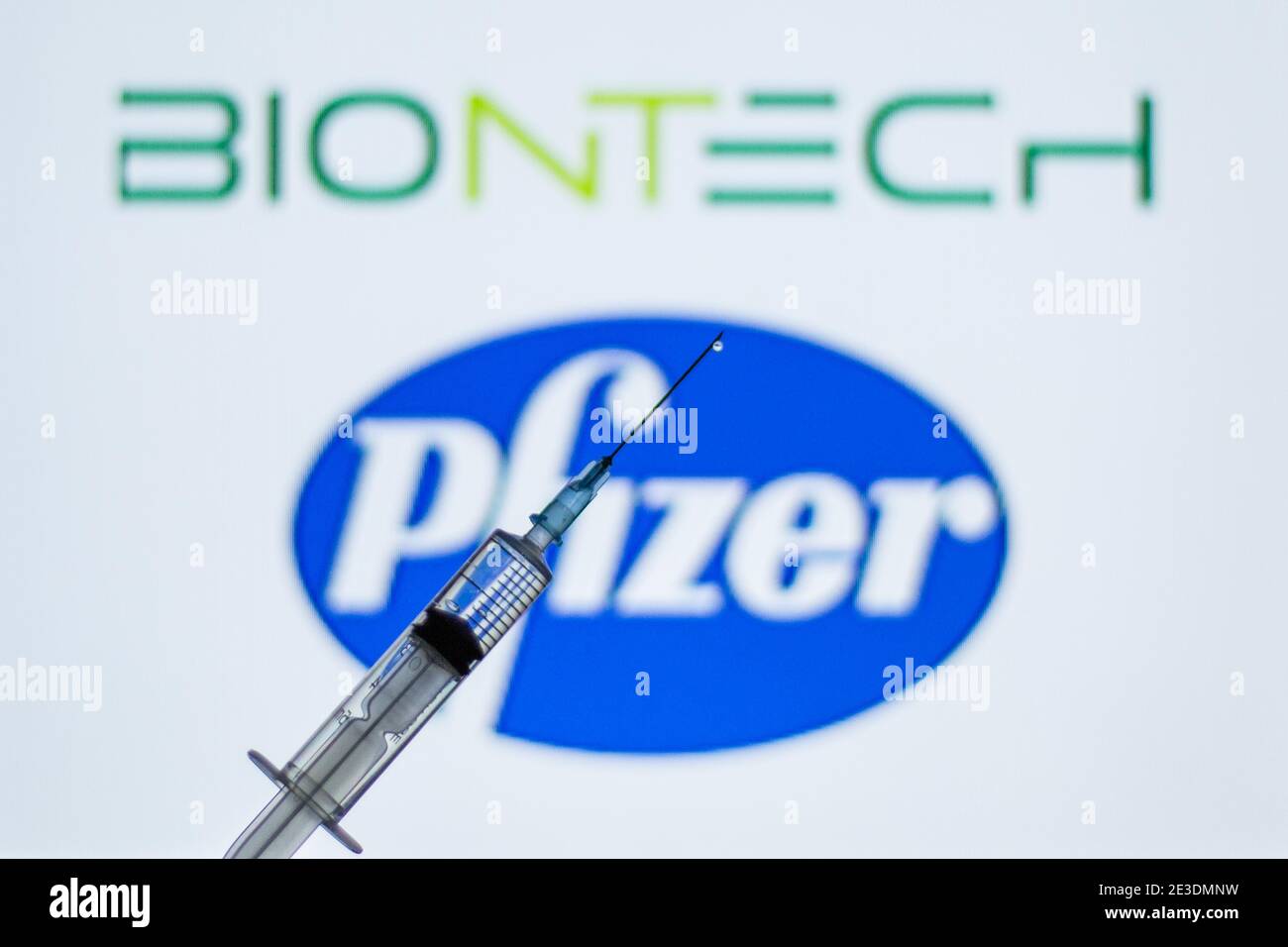 Barcelona, Catalonia, Spain. 18th Jan, 2021. In this illustration photo a syringe is seen in front of the Pfizer and BioNTech logo.Spain begins to administer the second dose of the Pfizer and BioNTech drug vaccine and the first dose (35,700 doses) of Moderna's drug has been incorporated, which also requires two injections per person. Credit: Thiago Prudencio/DAX/ZUMA Wire/Alamy Live News Stock Photo