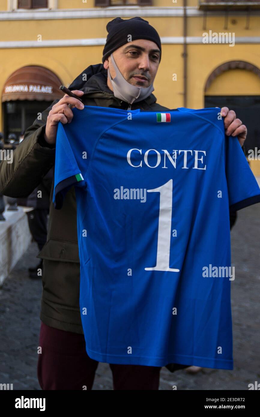 Rome Italy , January 18th 2021 Supporter of the Italian Prime Minister Giuseppe Conte holding Italy's football team jersey.   Rome, 18/01/2021. Italian Members of Parliament outside the Chamber of Deputies (Italian Parliament lower house) while the Italian Prime Minister, Giuseppe Conte, asks the Chamber a vote of confidence to save the Italian Government after the defection of the two Cabinet ministers belonging to the tiny party, Italia Viva (Italy Alive), led by former Italian Prime Minister Matteo Renzi. Stock Photo