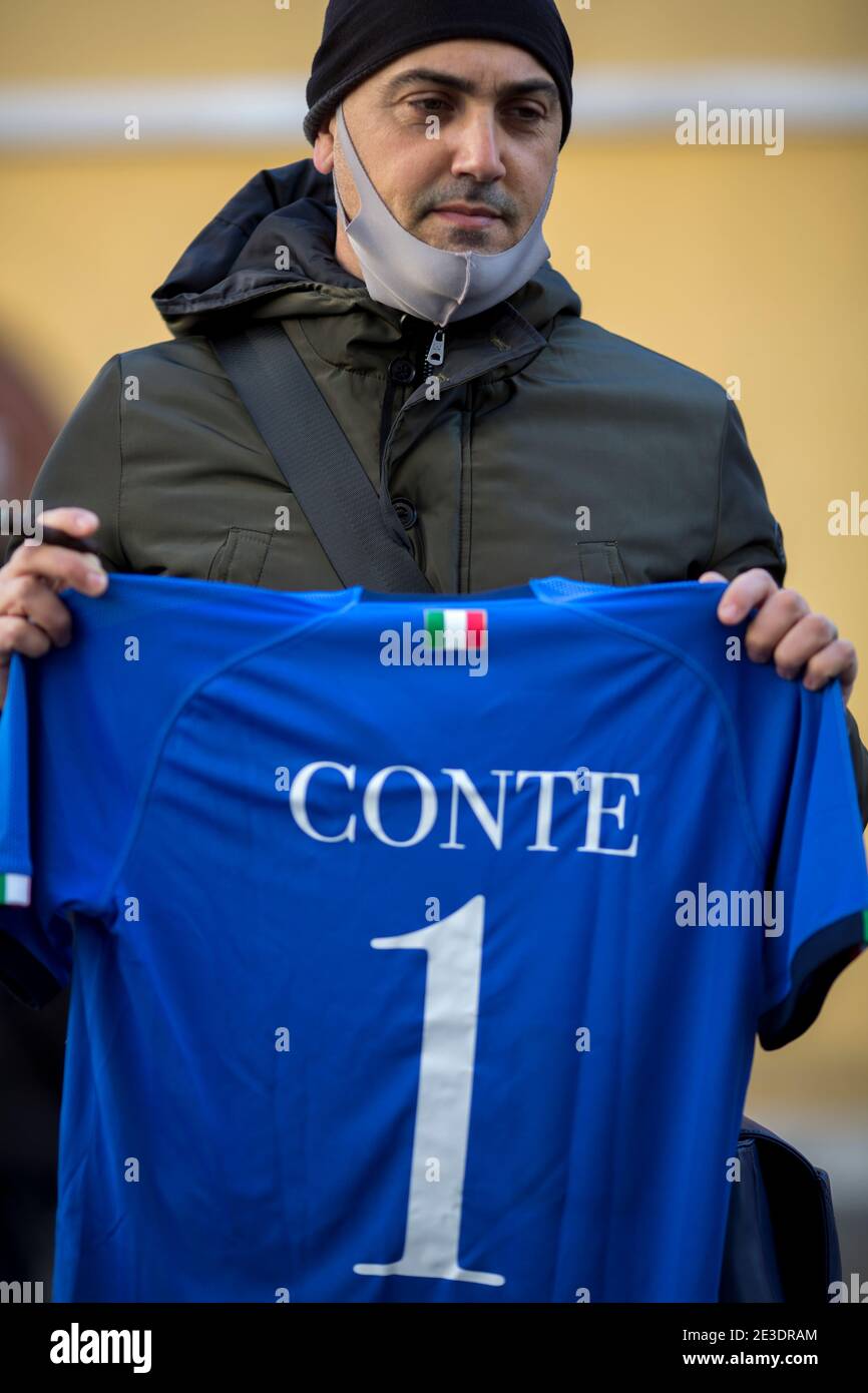 Rome Italy , January 18th 2021 Supporter of the Italian Prime Minister Giuseppe Conte holding Italy's football team jersey.   Rome, 18/01/2021. Italian Members of Parliament outside the Chamber of Deputies (Italian Parliament lower house) while the Italian Prime Minister, Giuseppe Conte, asks the Chamber a vote of confidence to save the Italian Government after the defection of the two Cabinet ministers belonging to the tiny party, Italia Viva (Italy Alive), led by former Italian Prime Minister Matteo Renzi. Stock Photo