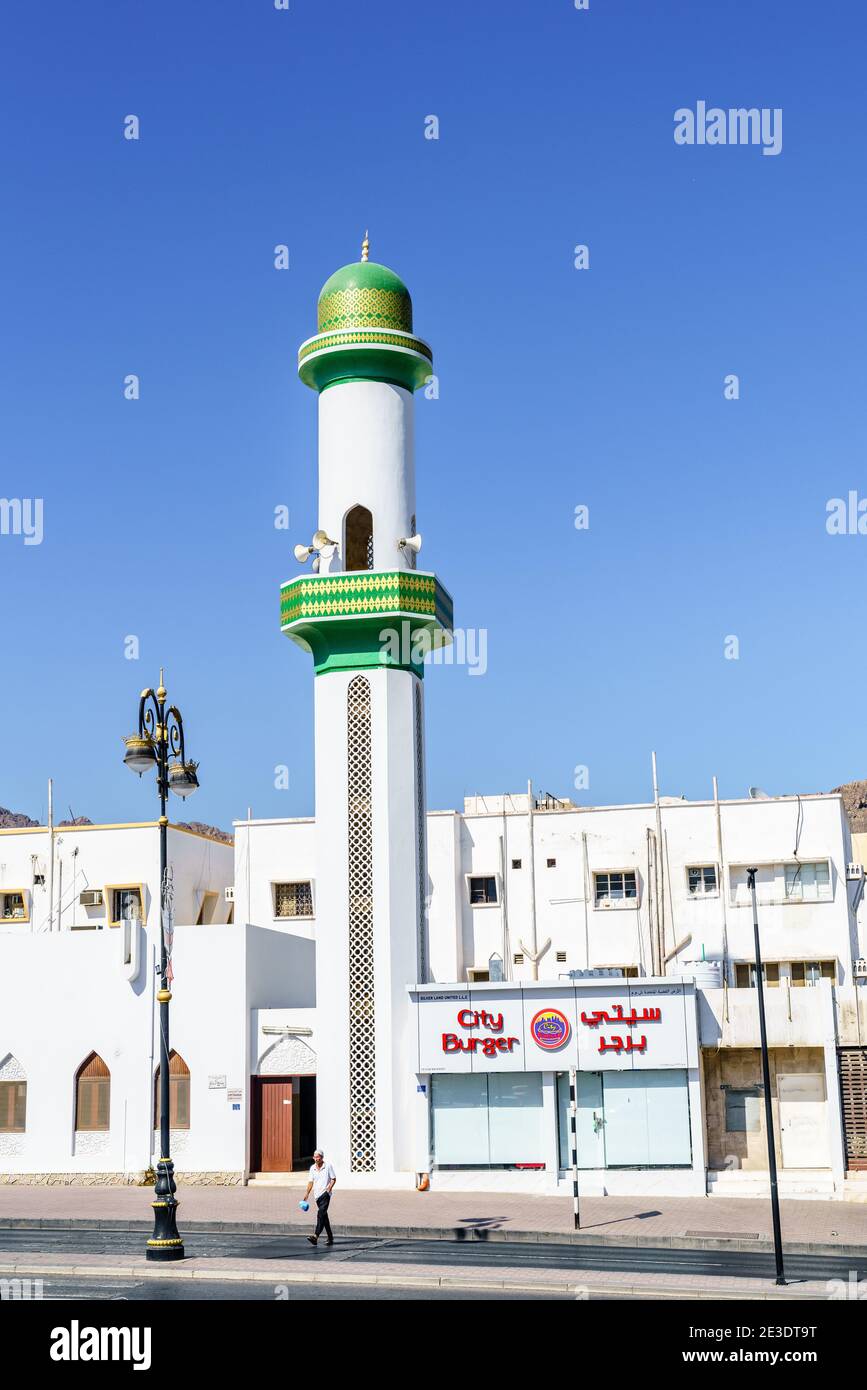 Muscat, Oman, December 3, 2016: A small mosque in Muscat, Oman next to a fast food restaurant Stock Photo