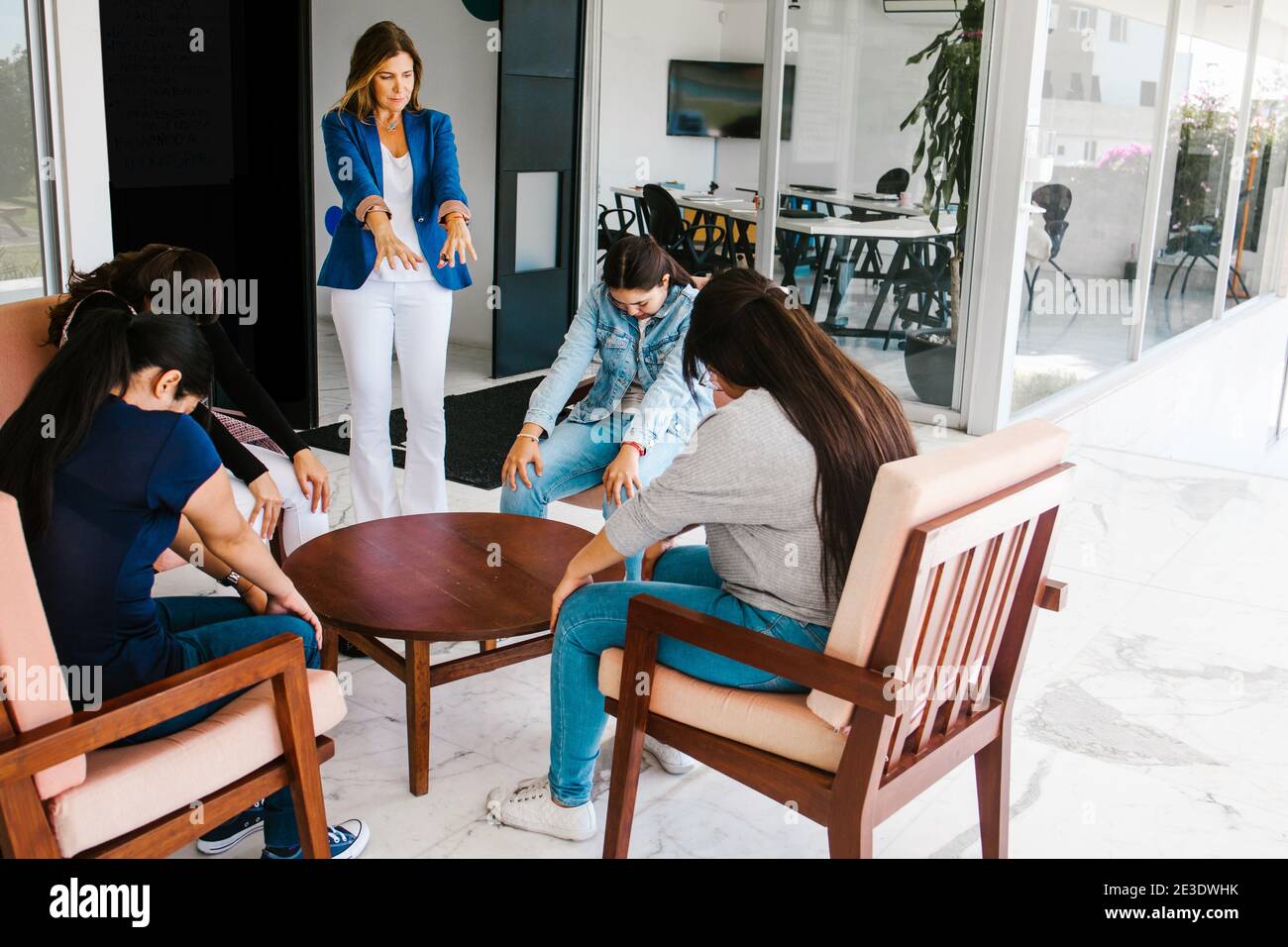 Creative latin business women meditating and practicing yoga in office ...