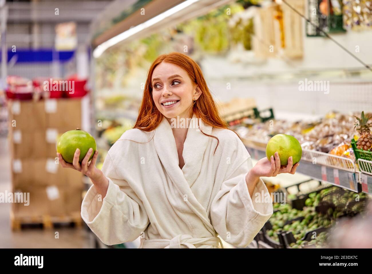 lady choosing fresh fruits in grocery store, woman in bathrobe enjoy